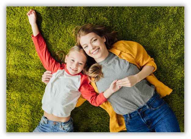 Mother and daughter laying in the grass